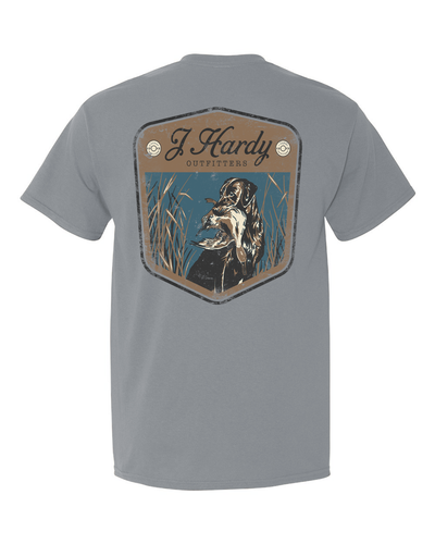 Celebrate the timeless bond between hunter and canine companion with our "Retro Dog Badge" t-shirt! This classic-fit tee features a vintage-inspired illustration of a hunting dog proudly holding a duck in its mouth, reminiscent of classic hunting patches and badges.